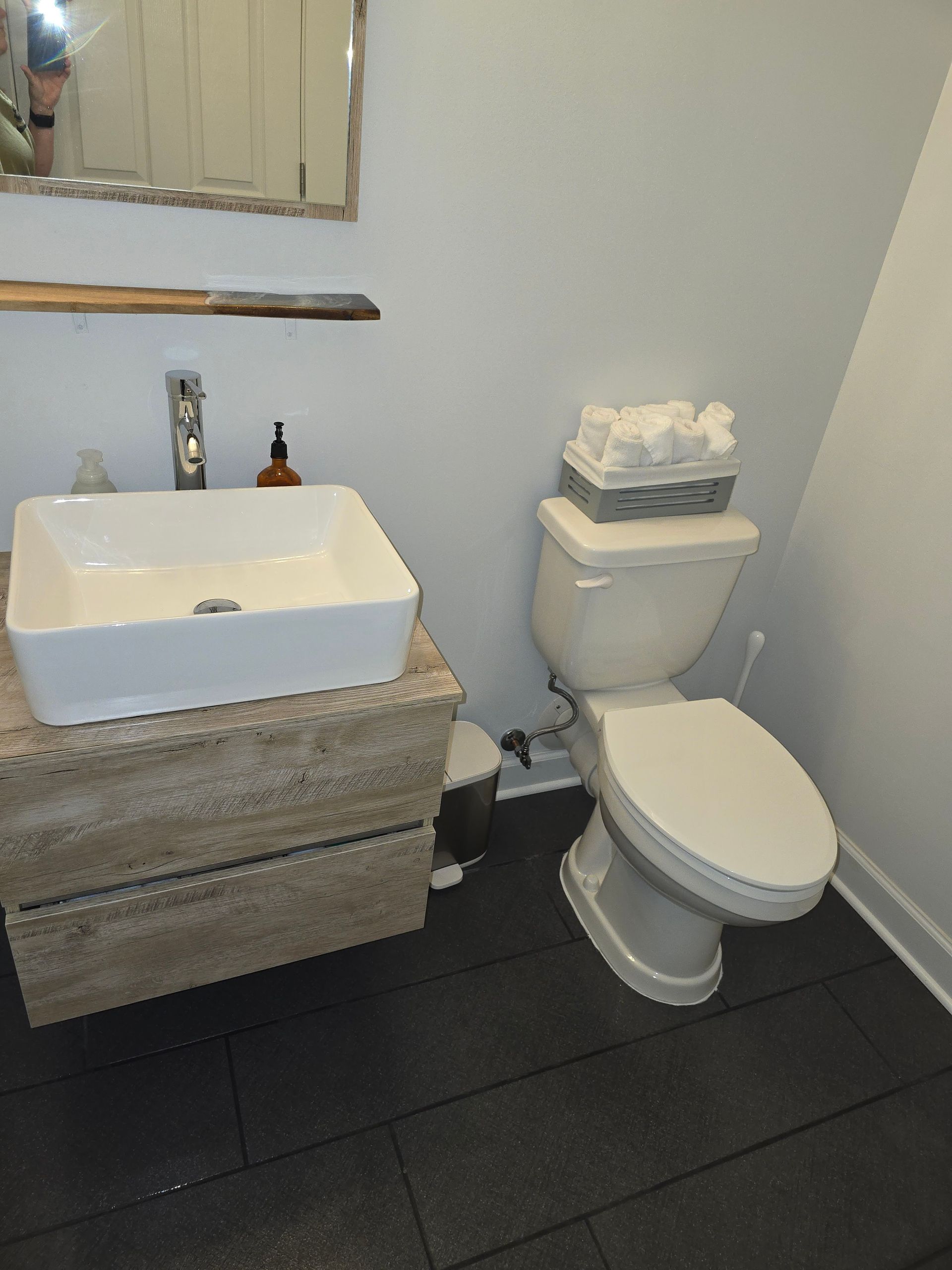 A bathroom with a toilet a sink and a mirror