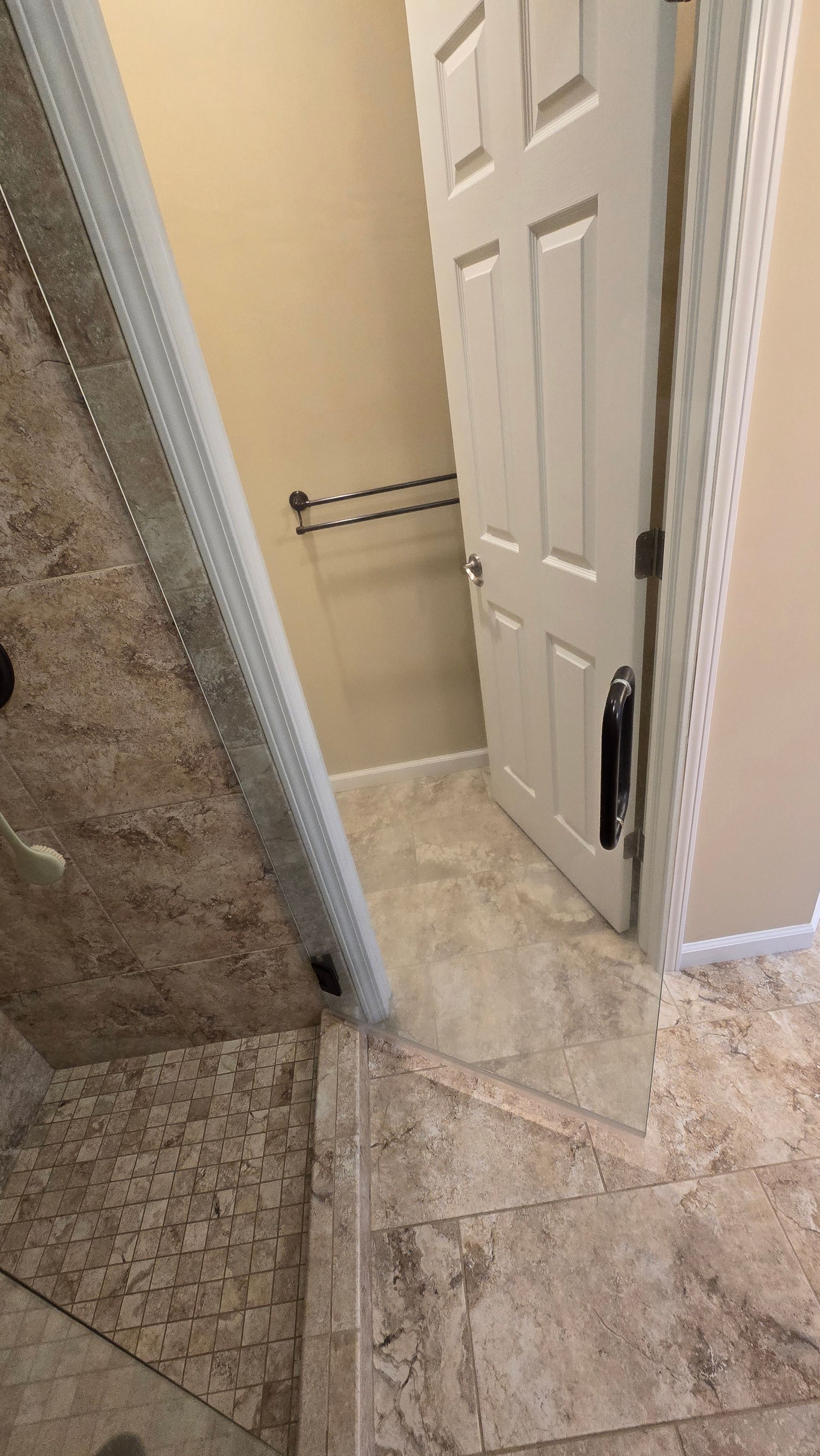 A bathroom with a tiled floor and a door that is open.