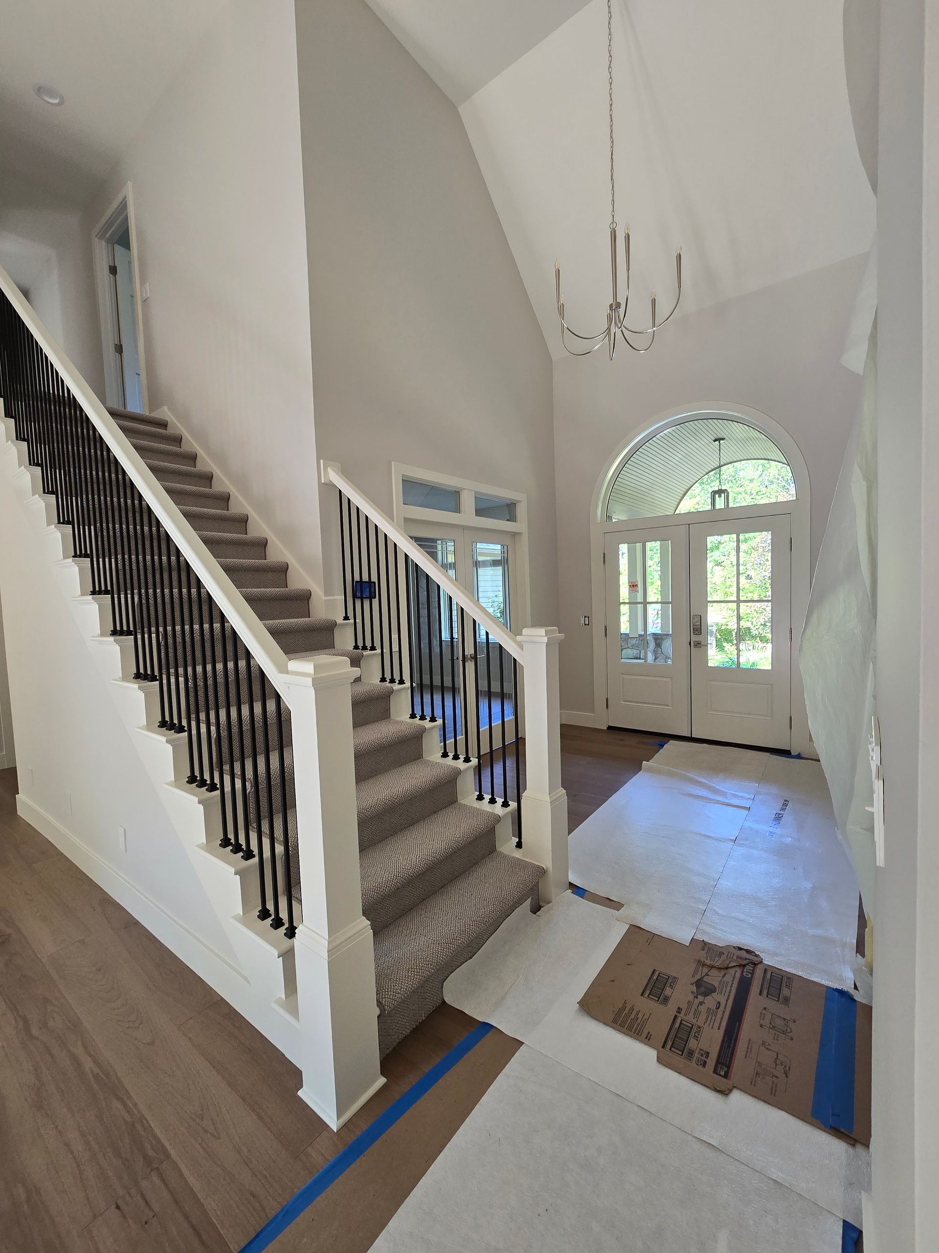 A staircase in a house with a chandelier hanging from the ceiling.