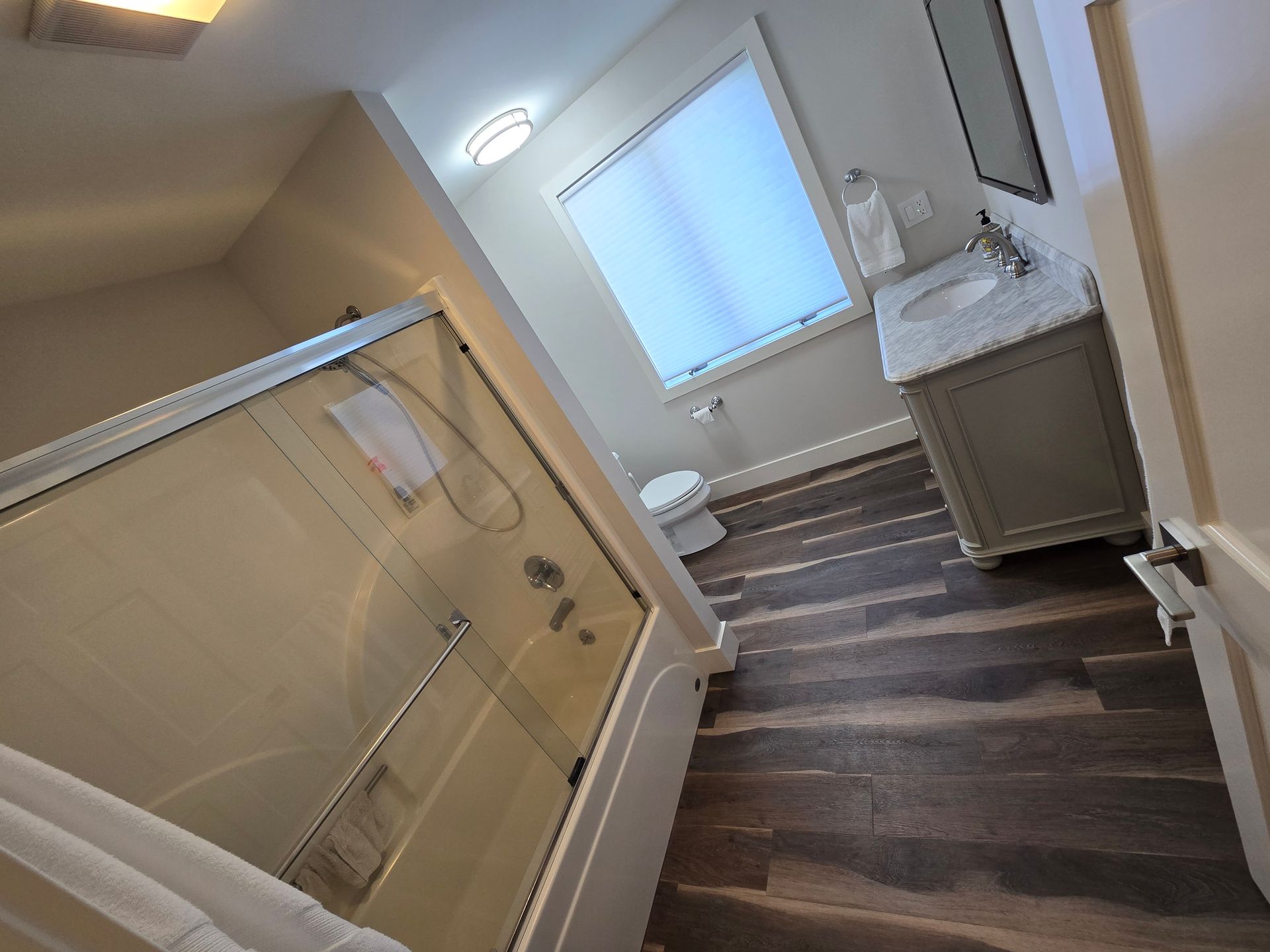 A bathroom with a tub , sink , toilet and shower.