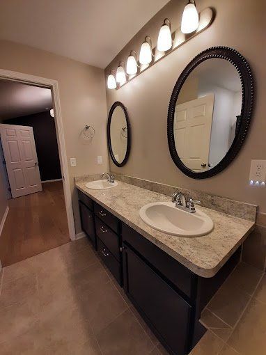 A bathroom with two sinks and two mirrors.