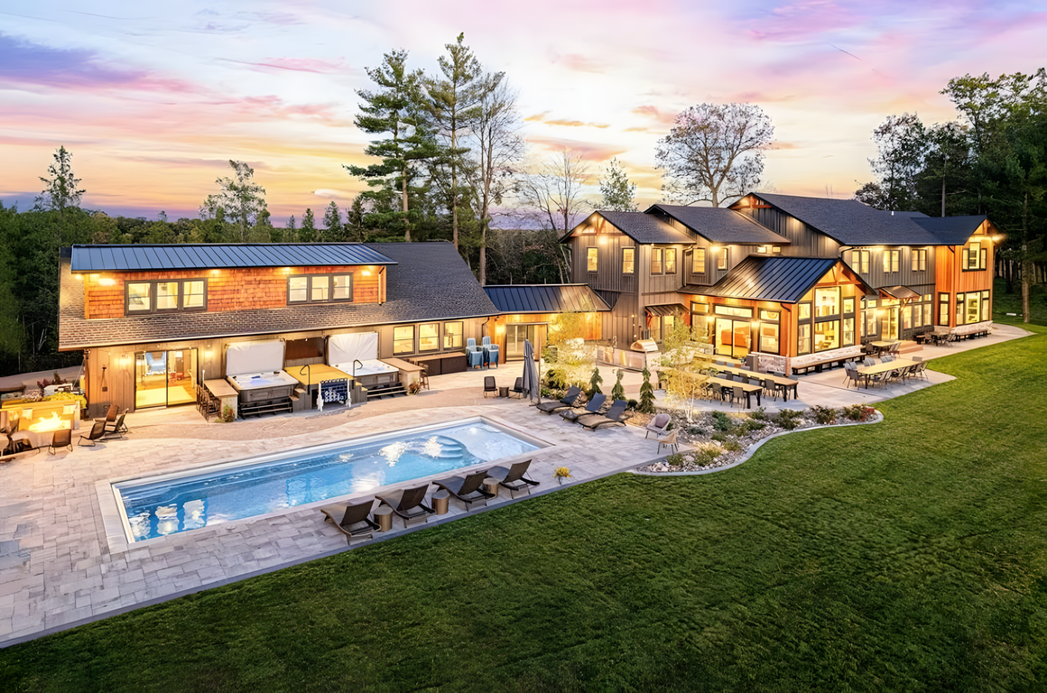 A large house with a large swimming pool in front of it.