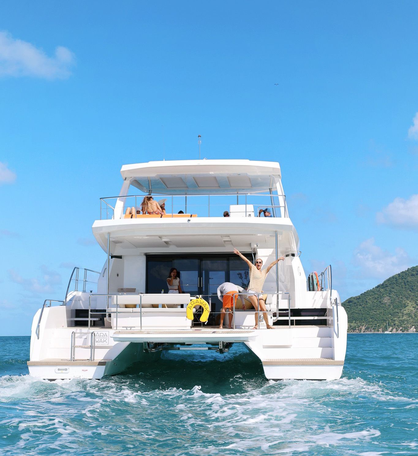 View of the Arawak Charters boat from behind with guests enjoying their day