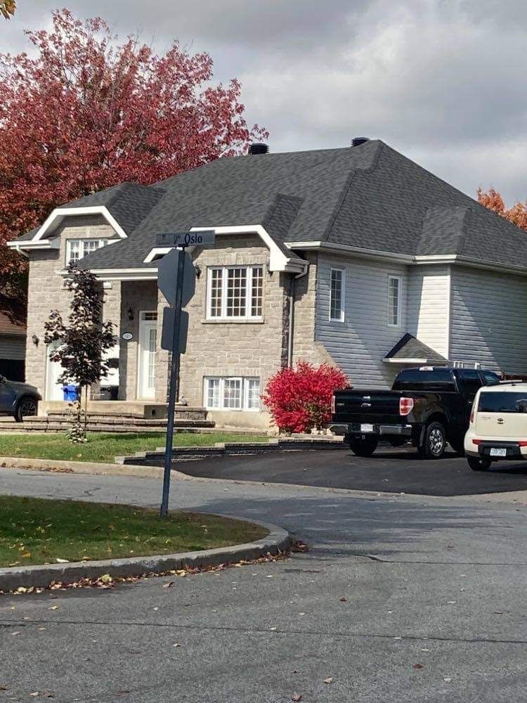 Une maison blanche avec un camion noir garé devant