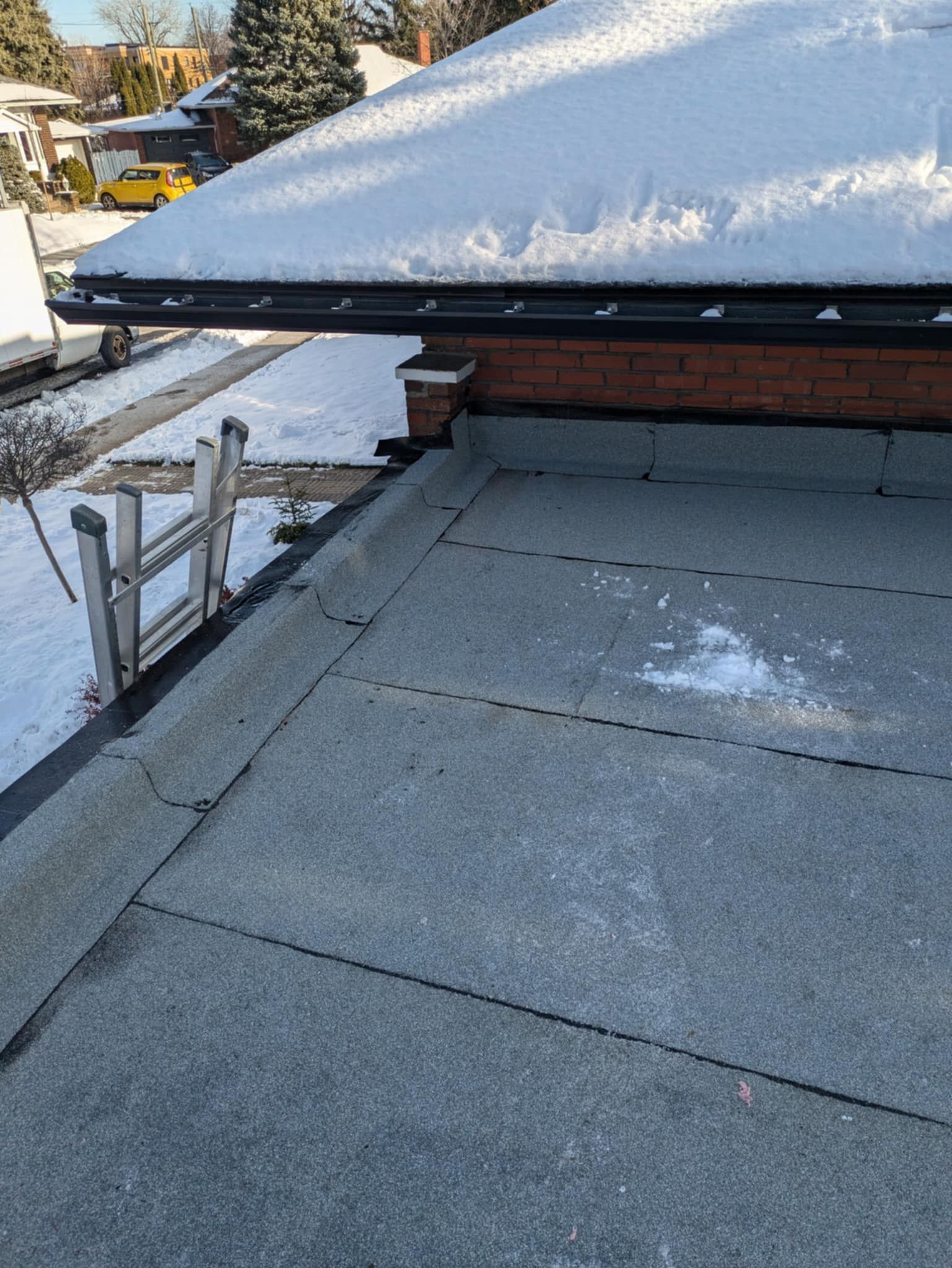 Un toit avec de la neige dessus et une échelle dessus.