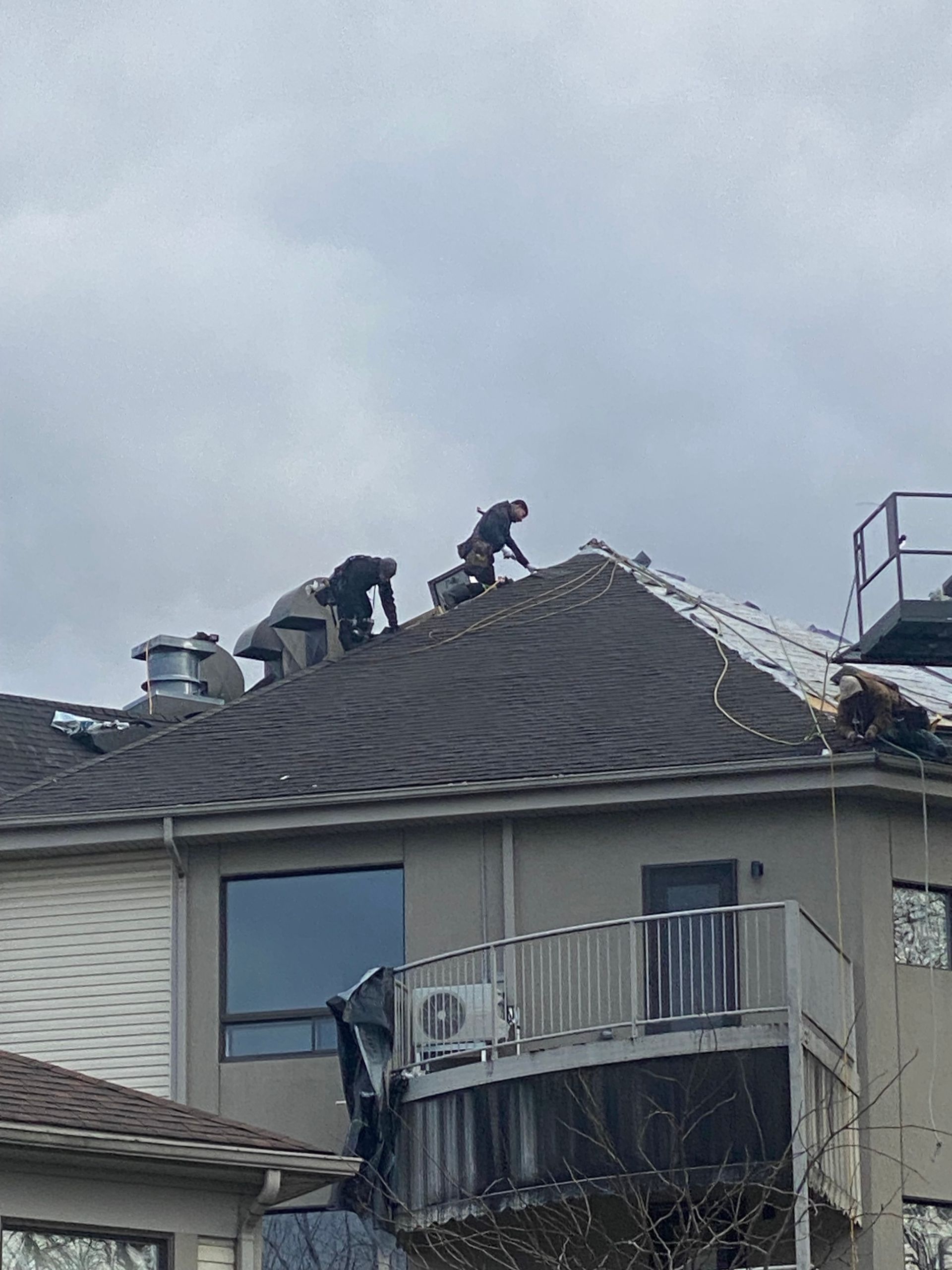 Un groupe de personnes travaille sur le toit d'une maison.