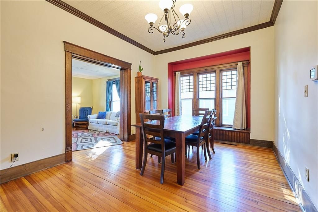 A man is looking at a model house with a magnifying glass.