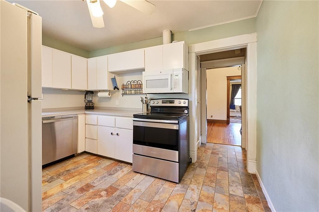 A kitchen area with oven and refrigerator