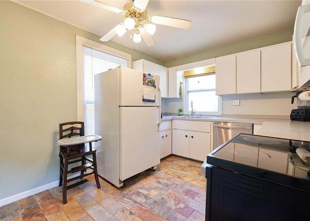 A kitchen area with refrigerator.