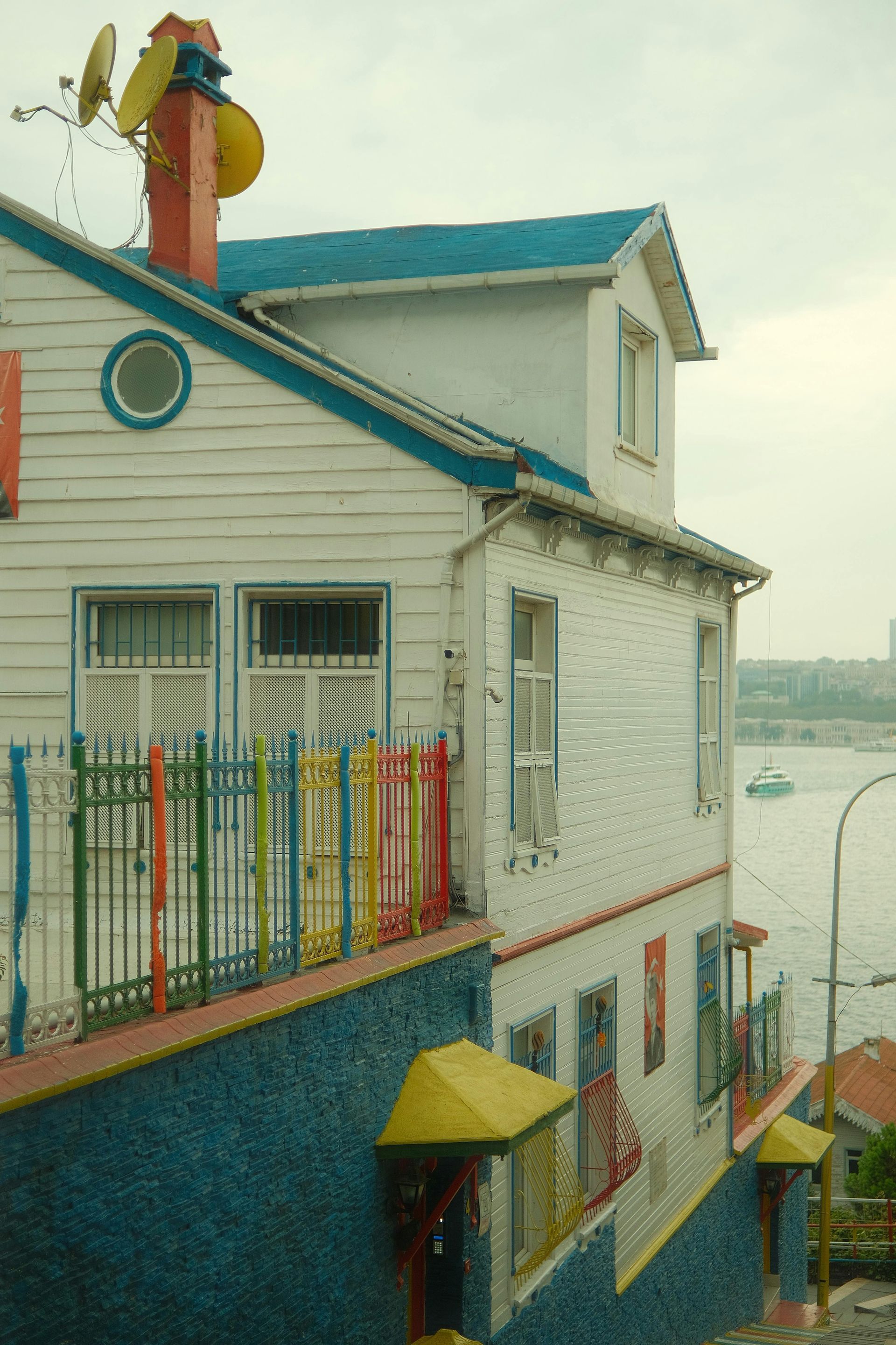 Colorful house with white siding, blue trim, and a rooftop weather station.