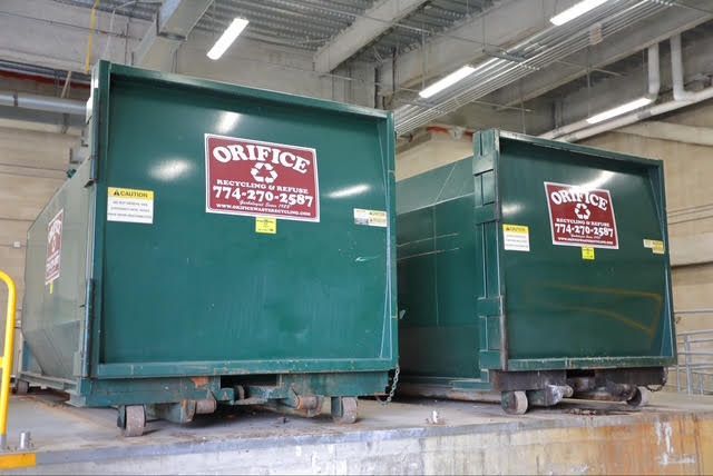 Two green Orifice dumpsters with