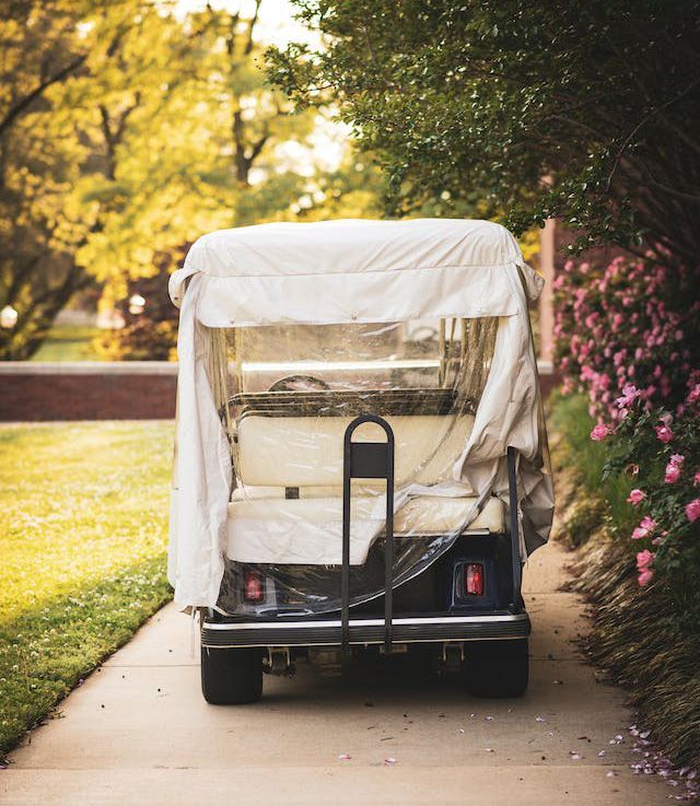 a golf cart with a canopy is parked on a sidewalk .