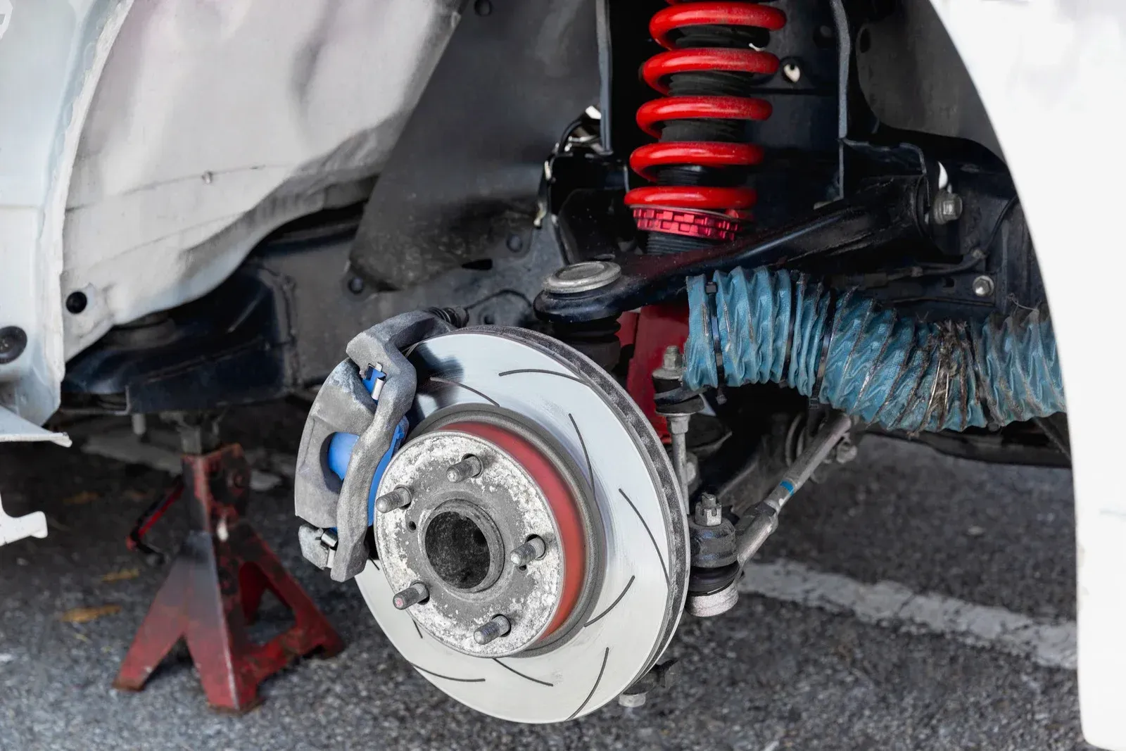 A close up of a car 's brake system on a jack.