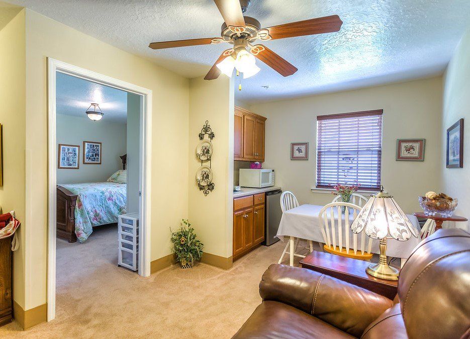 Cozy studio apartment with living area, small kitchen, and bedroom visible through doorway.