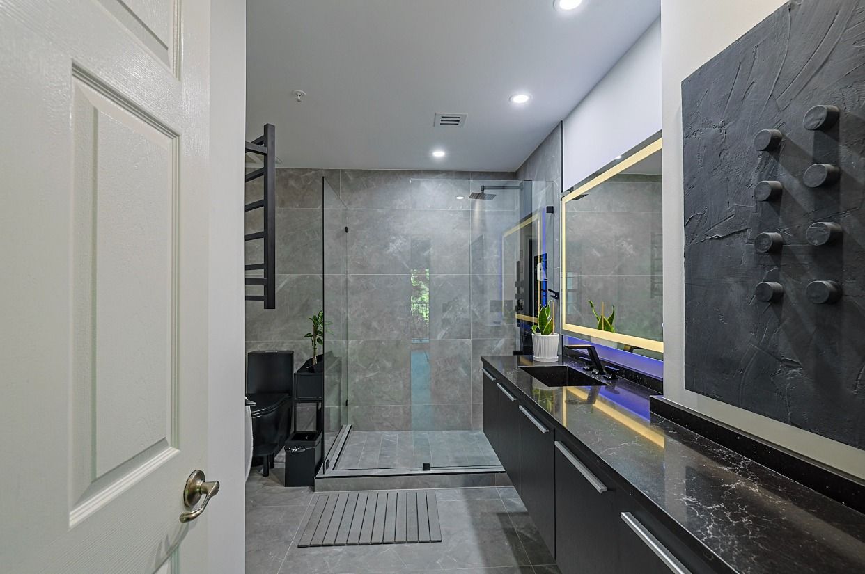A bathroom with a walk in shower , sink and mirror.