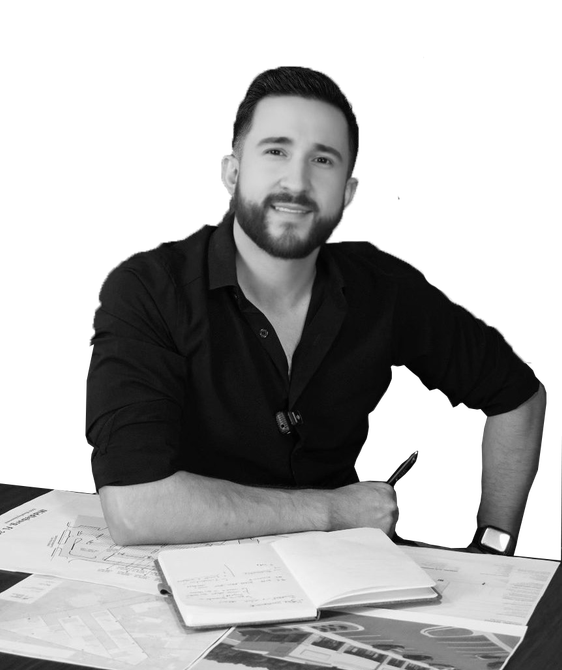 Man with dark hair and a goatee, wearing a grey button-up shirt, smiles at the camera.