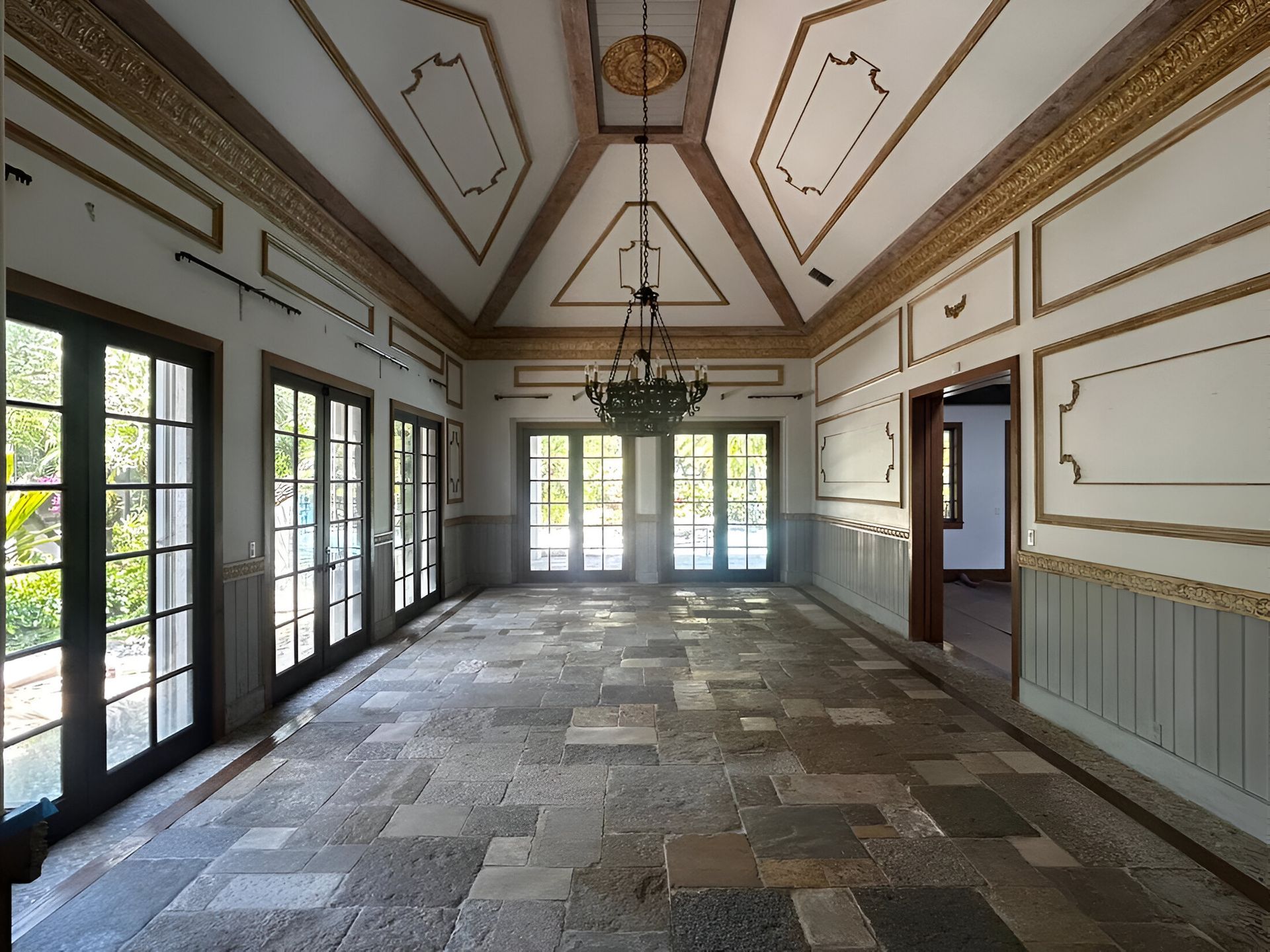 An empty room with a chandelier hanging from the ceiling