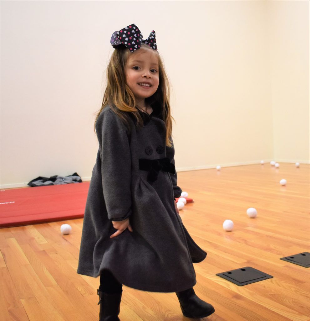 A little boy is holding a stick in front of a stuffed horse