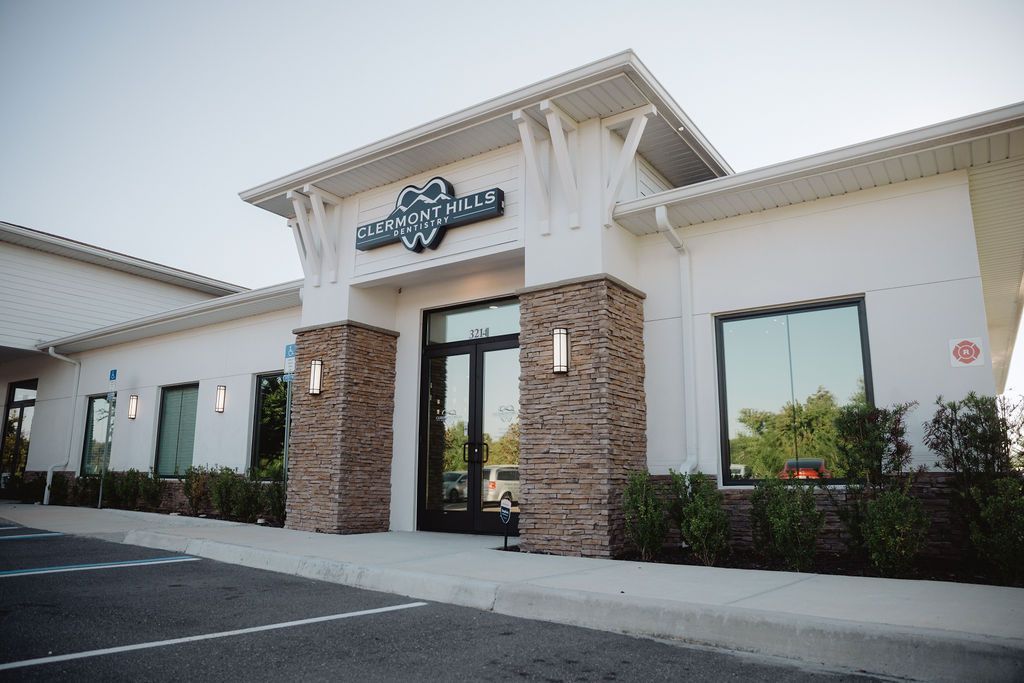 White building with stone pillars, large windows, and a sign that reads 