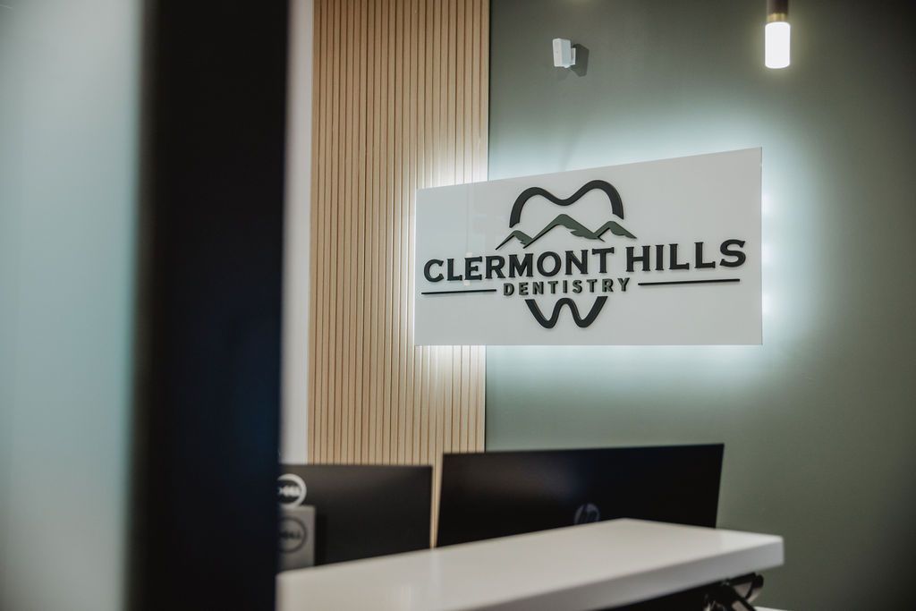 Reception area of Clermont Hills Dentistry; illuminated sign with logo over a desk.