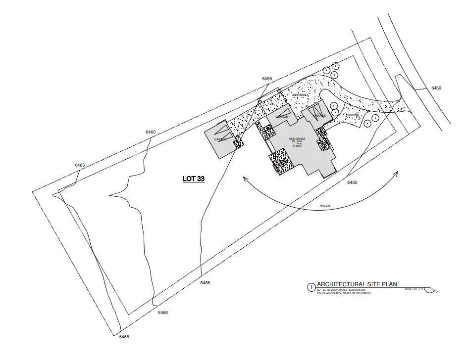Architectural site plan of a residential property; outlines of buildings, lot boundaries, and a driveway.