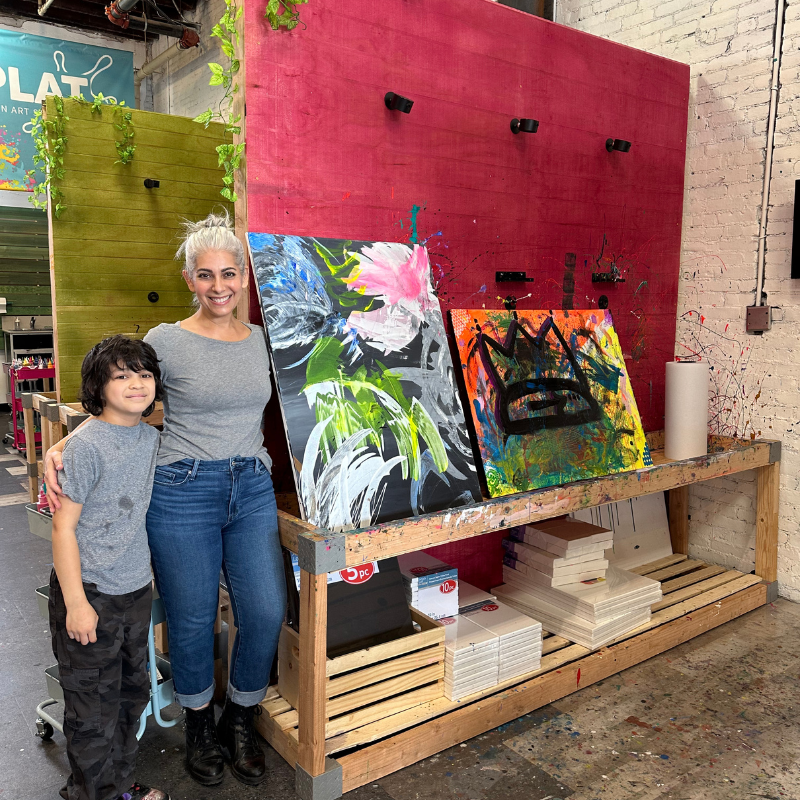 a woman in a hat is painting on a wall