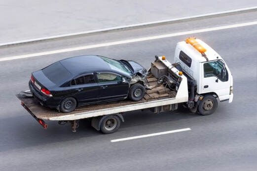 Damaged blue car being towed