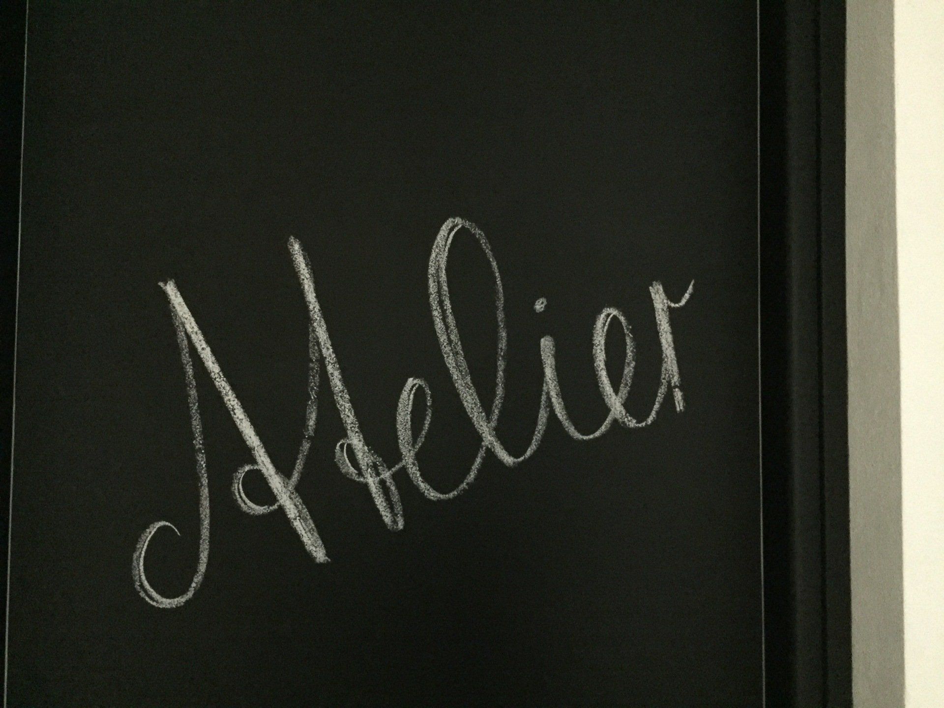 Tafel mit dem Wort Atelier in Handschrift