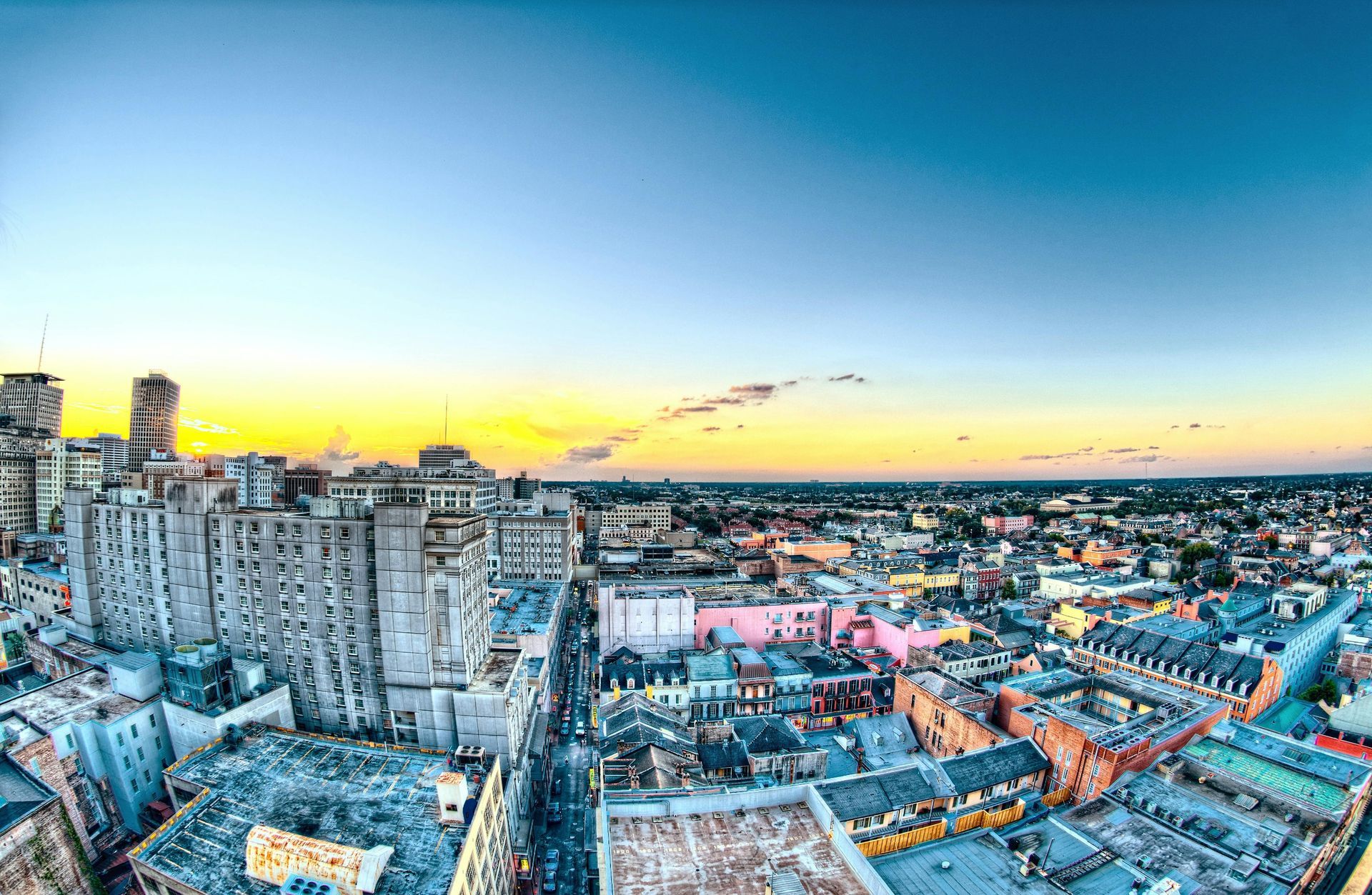 City skyline at sunset, tall buildings, orange and blue sky.