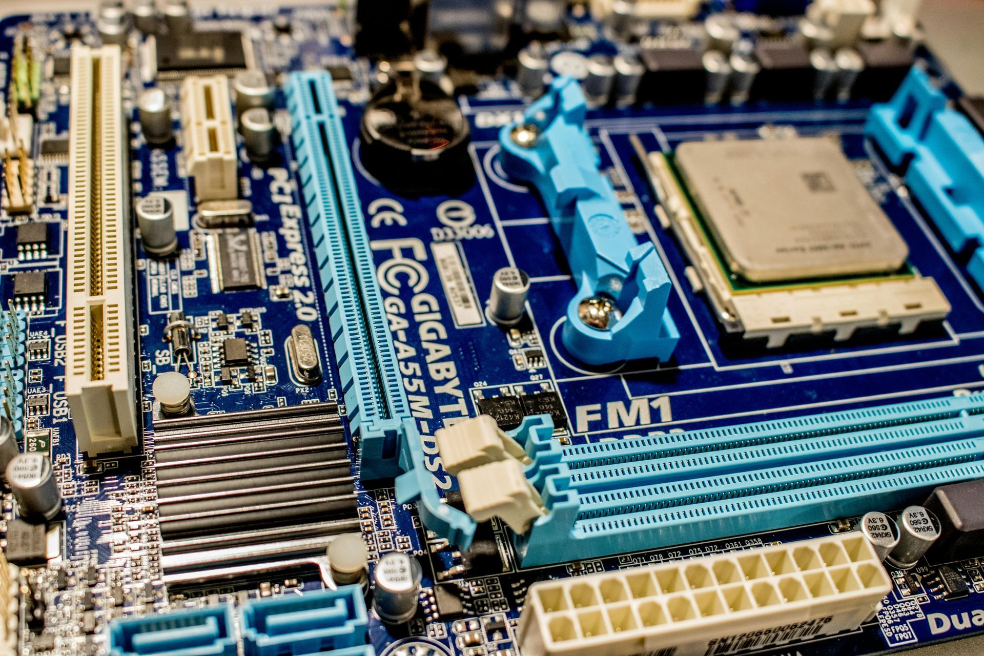 Close-up of a blue and white computer motherboard with various components and connectors.