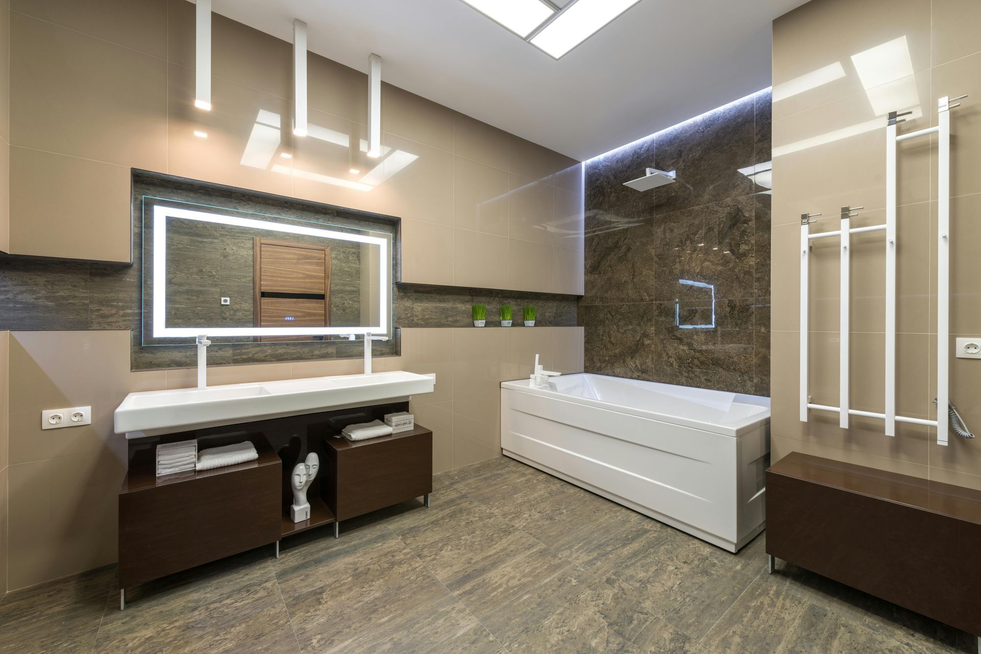 Modern bathroom with a rectangular tub, shower, and vanity with a lighted mirror.