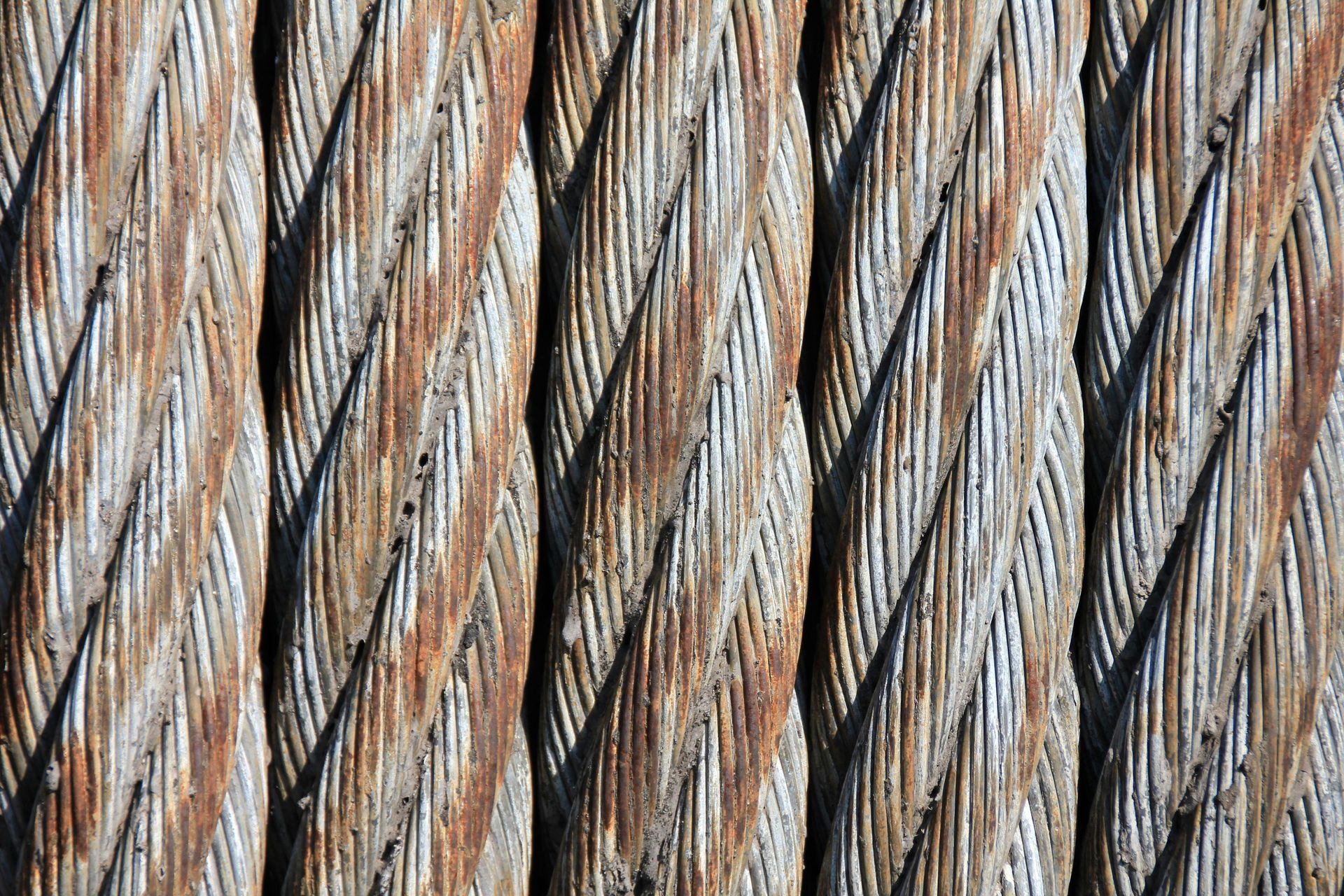 Close-up of weathered wooden beams with a twisted, ridged pattern; brown and gray tones.