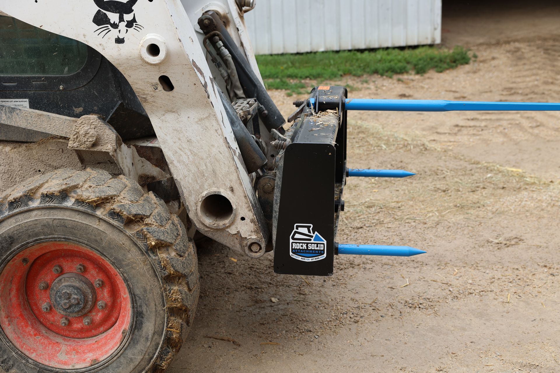 A bobcat tractor with a fork attached to it.