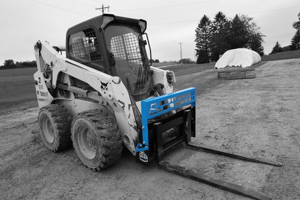 A bobcat skid steer is parked on a dirt road.