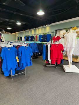 Clothing store with racks of blue, red, and white apparel under bright overhead lights