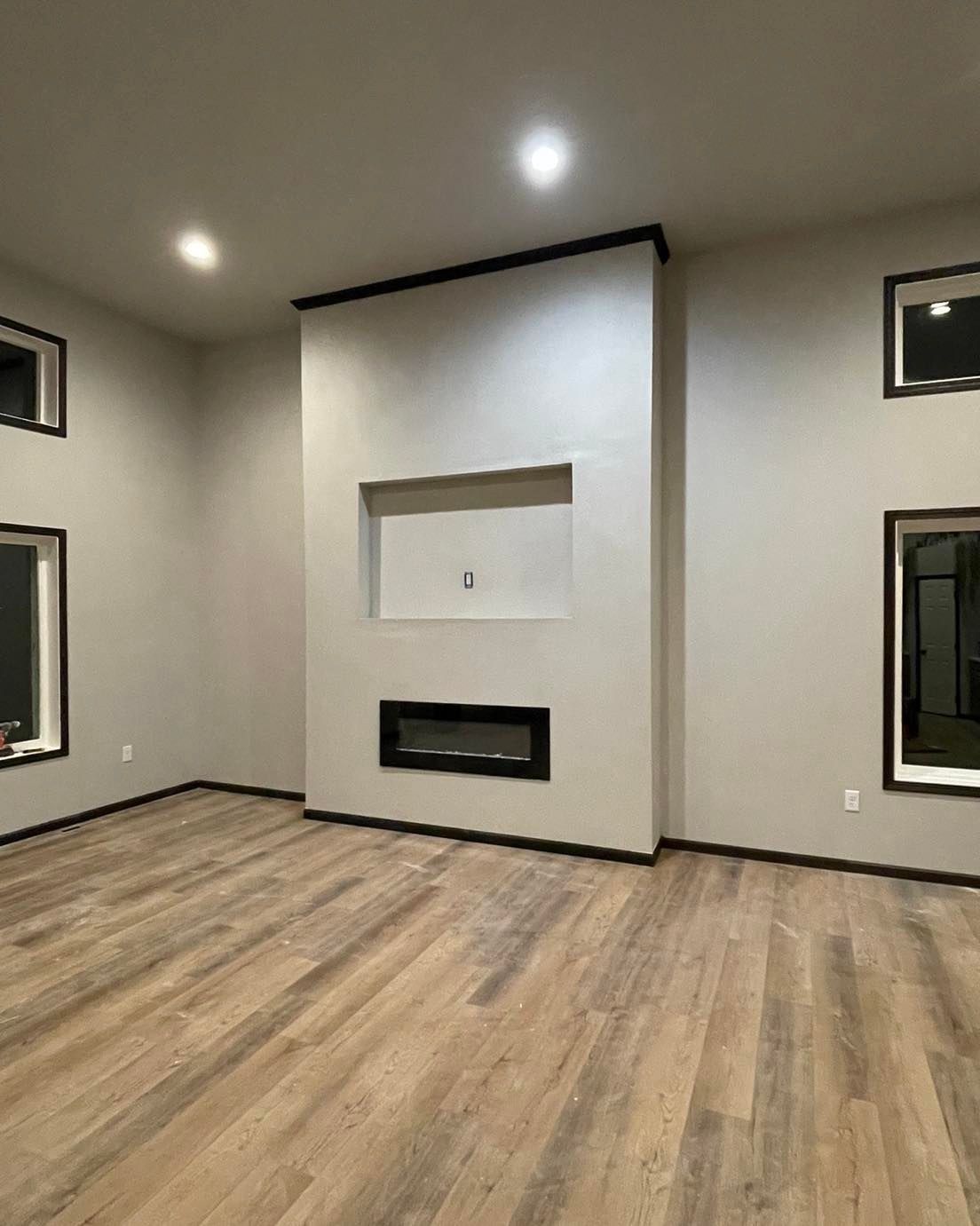 An empty living room with hardwood floors and a fireplace.