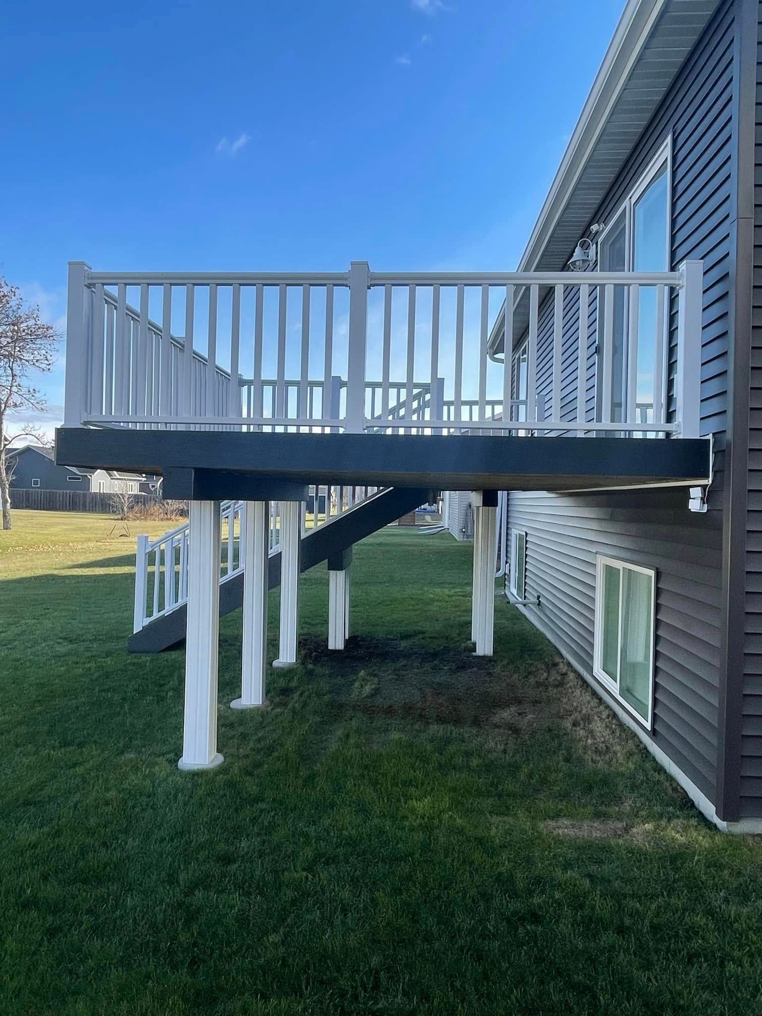 A large deck is sitting on the side of a house.