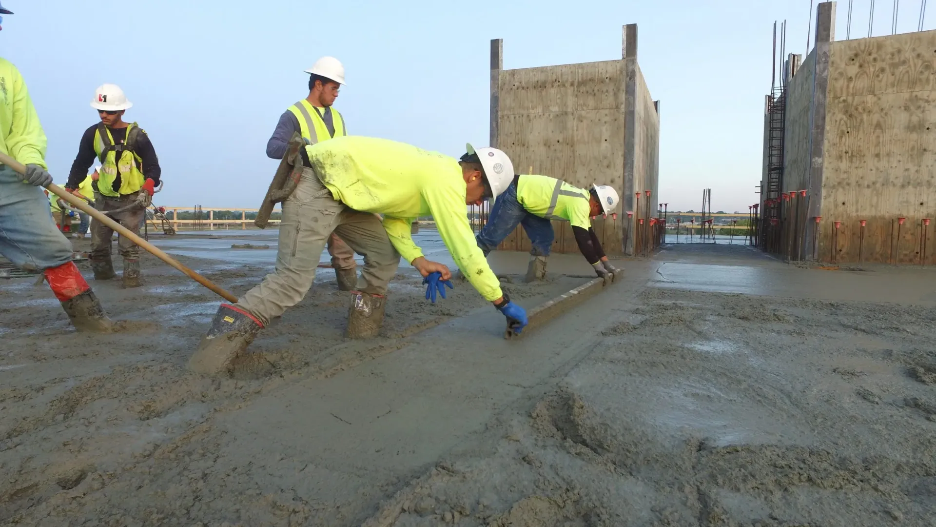 A group of construction workers are working on a sidewalk.