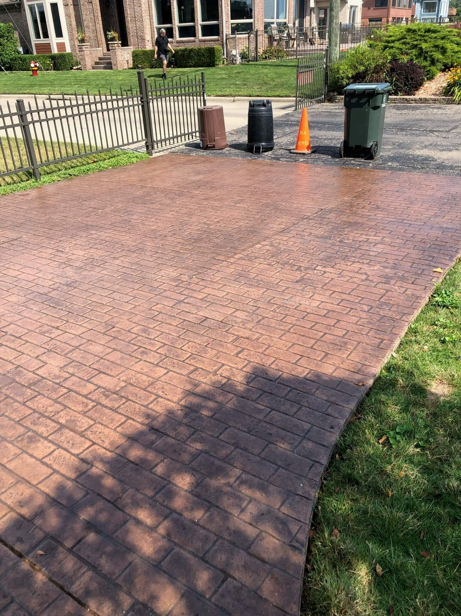 A brick walkway with a car parked on the side of it