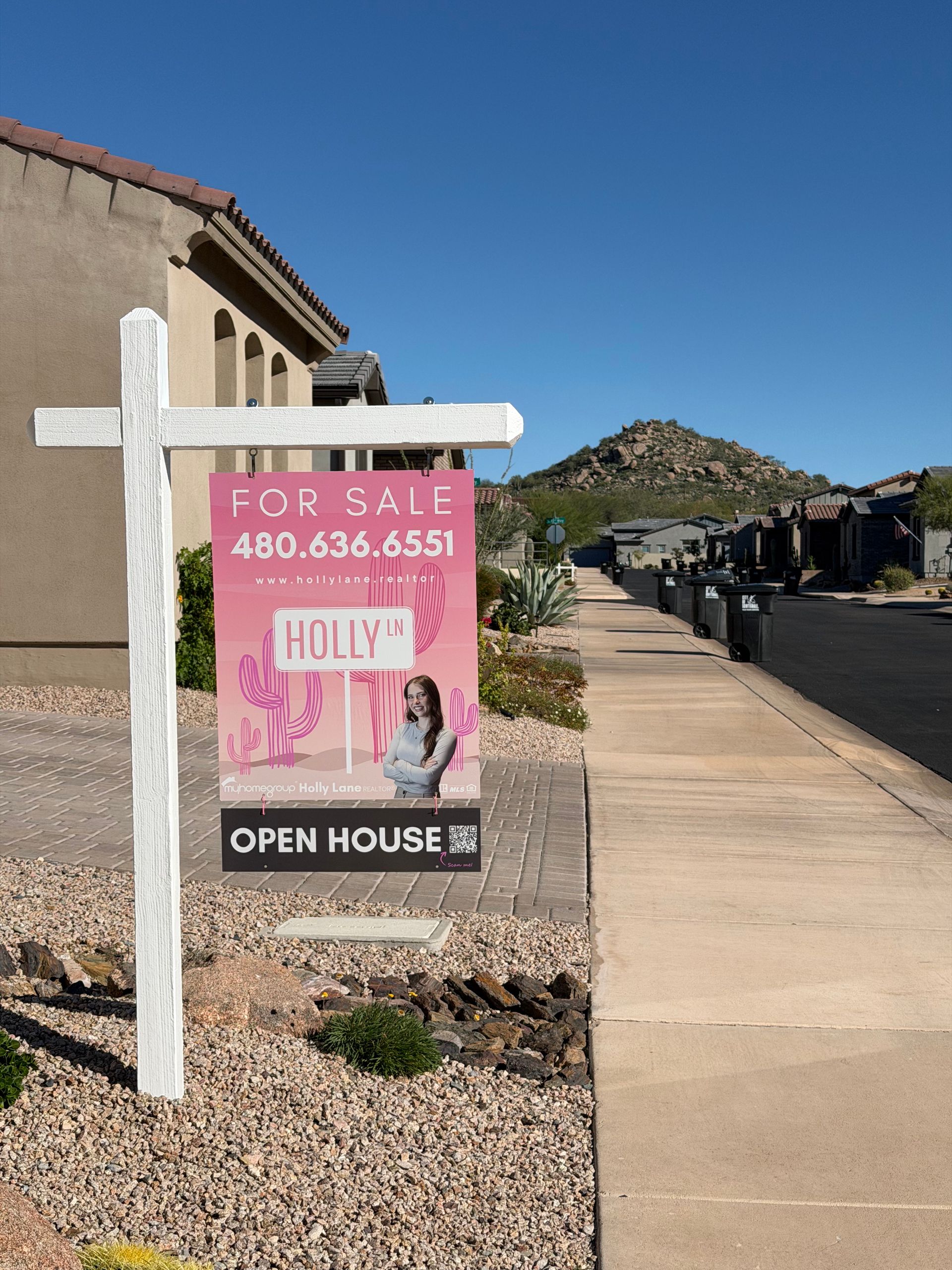 Two people at a table with a home model signing a contract.