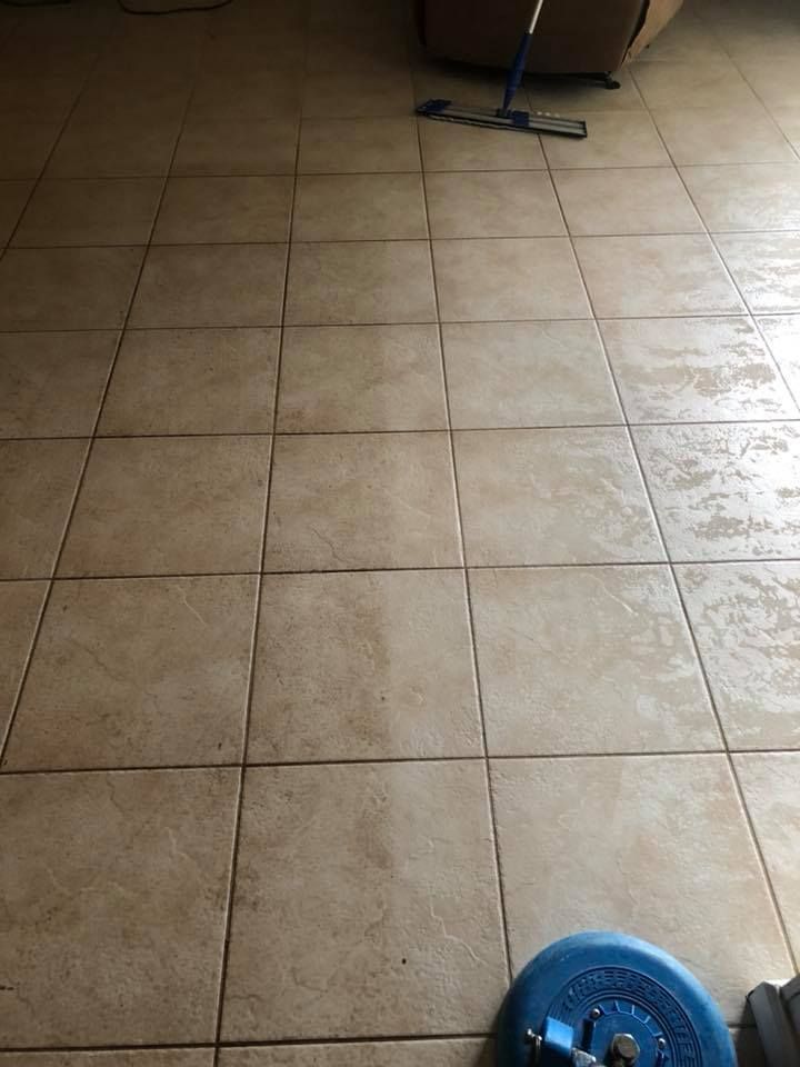 A mop is sitting on a tiled floor in a living room.
