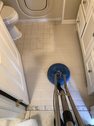 A vacuum cleaner is sitting on the floor of a bathroom next to a toilet.