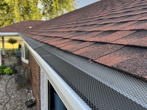 A close up of a gutter on a roof of a house.