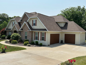 A large white house with a brown garage door