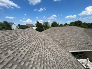 The roof of a house with a blue sky in the background