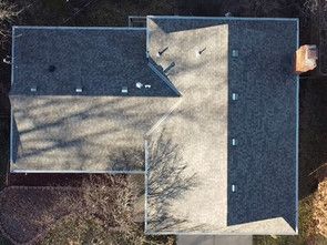 An aerial view of a house with a black roof.