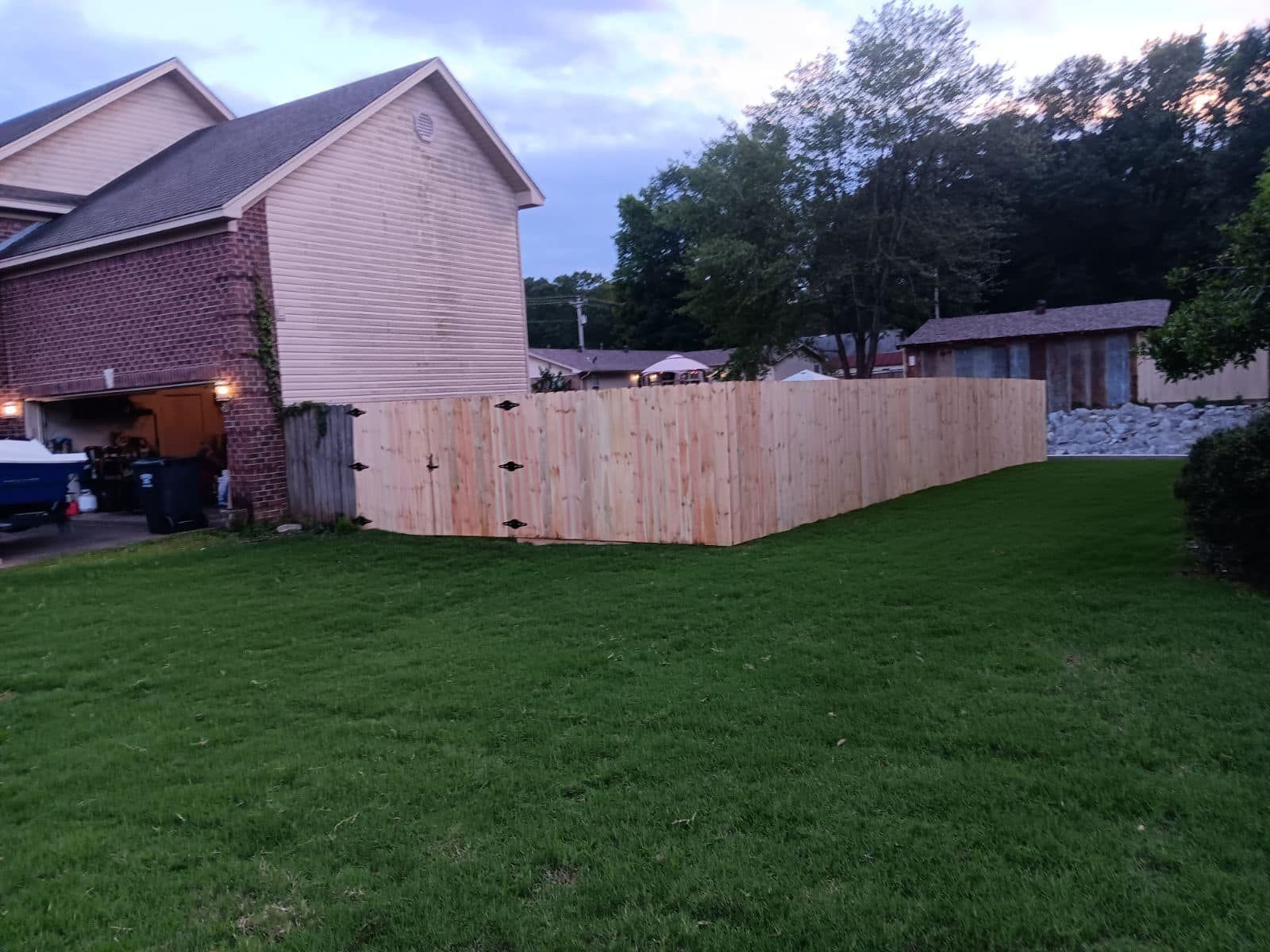 A wooden fence in little rock, ar is in the backyard of a house.
