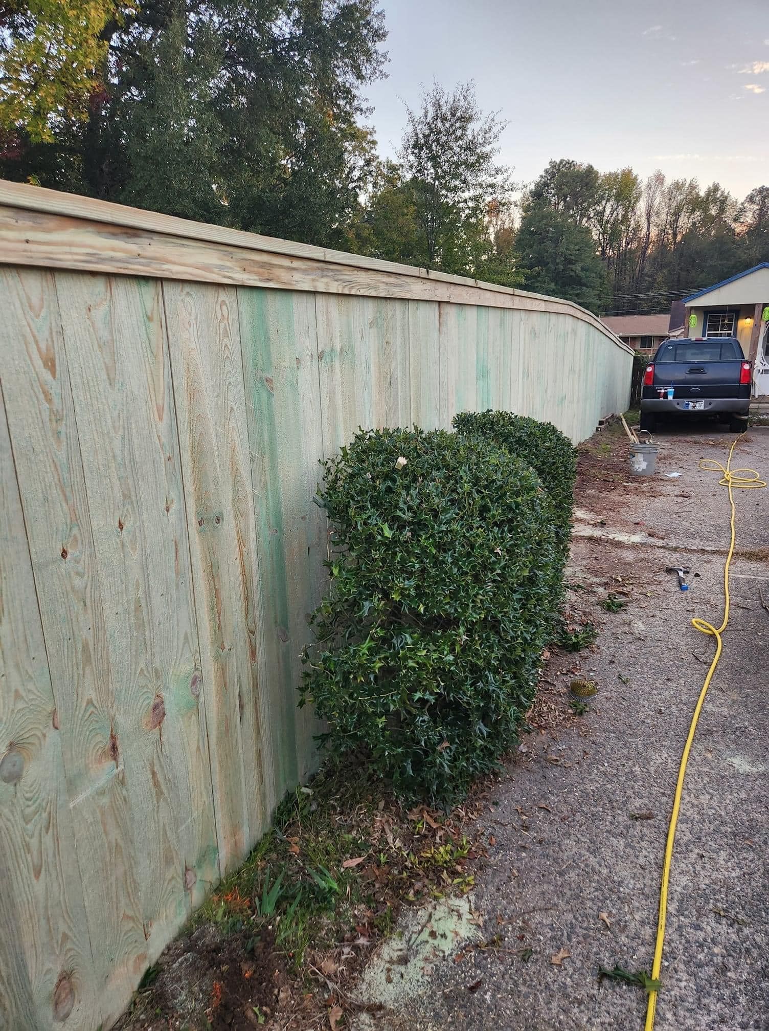 A wooden fence is being built in front of a house.
