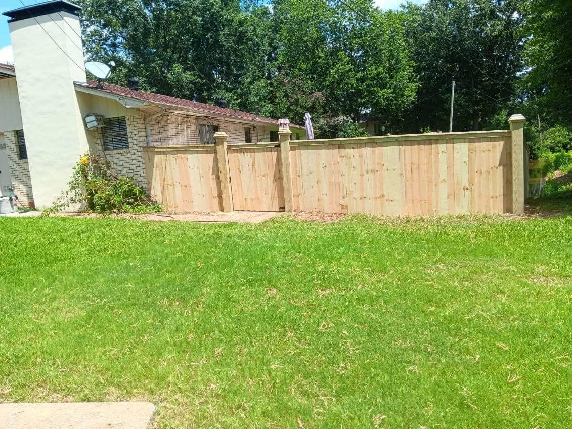 There is a wooden fence in the backyard of a house.