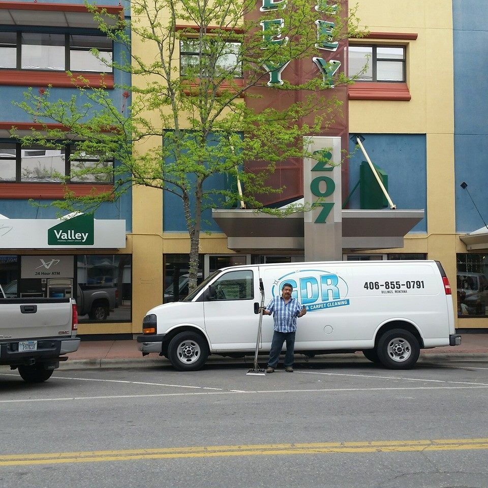 A cdr van is parked in front of a building